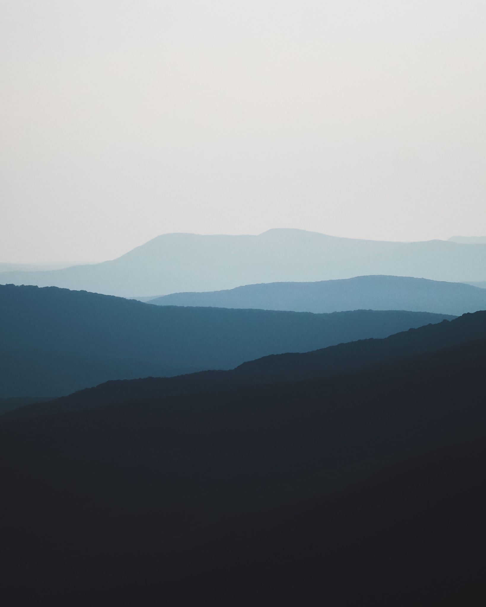 A peaceful landscape of silhouetted mountains under a twilight sky, capturing serene beauty.