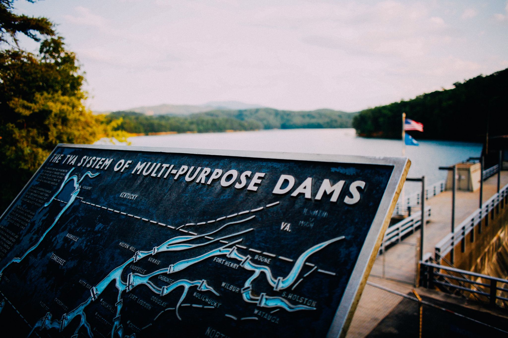 Captivating view of Ocoee Dam with map sign at sunset, showcasing serene natural beauty.
